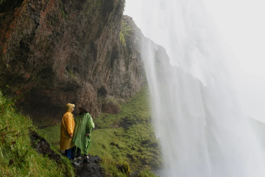 A young man standing on a hill, admiring at the falls