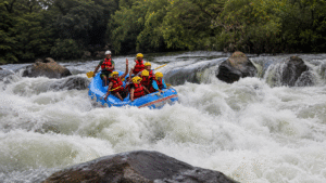 Group of people enjoying whitewater rafting in Coorg surrounded by lush greenery and rushing river rapids during an adventurous yet relaxing vacation experience