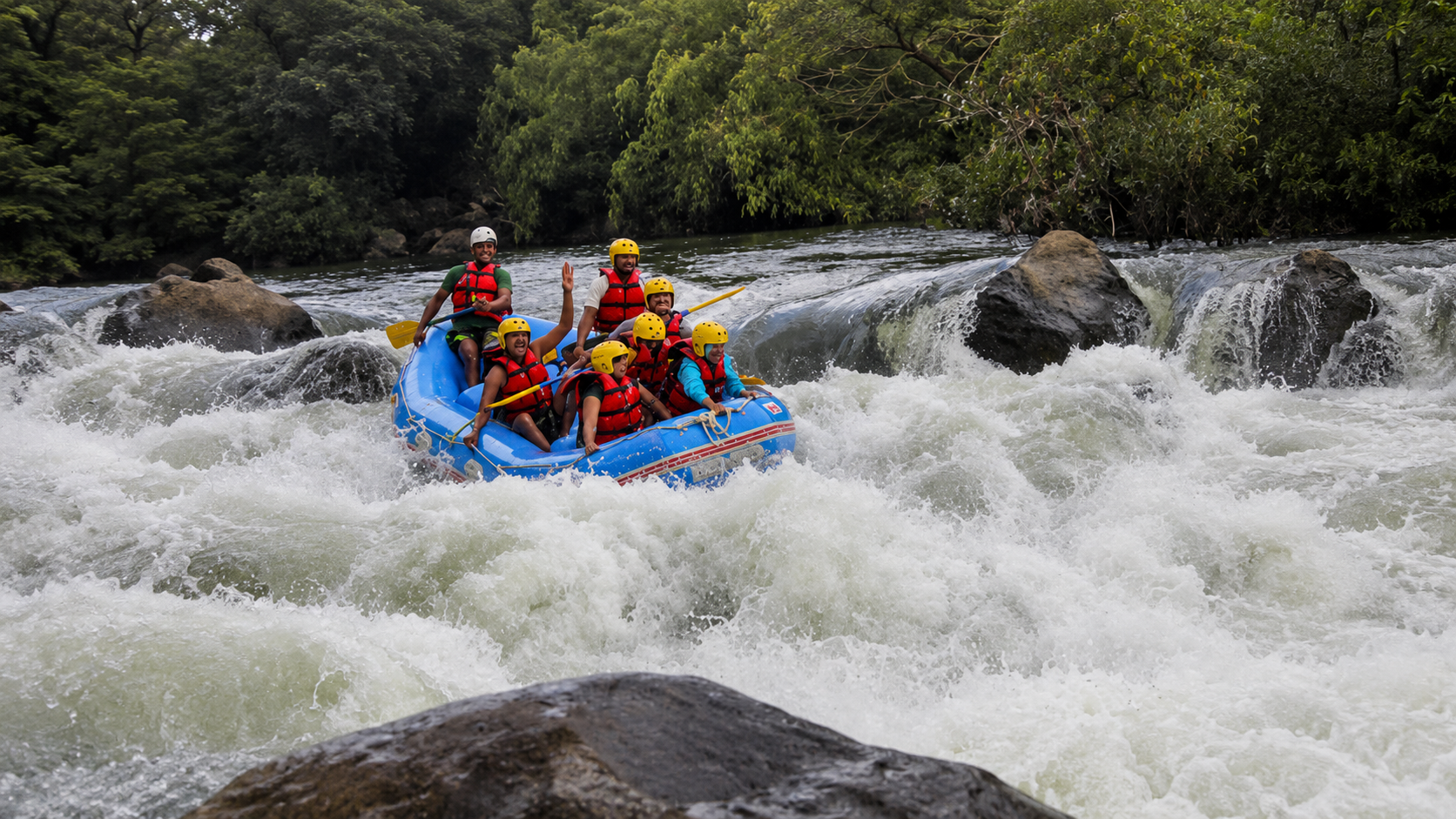 Group of people enjoying whitewater rafting in Coorg surrounded by lush greenery and rushing river rapids during an adventurous yet relaxing vacation experience