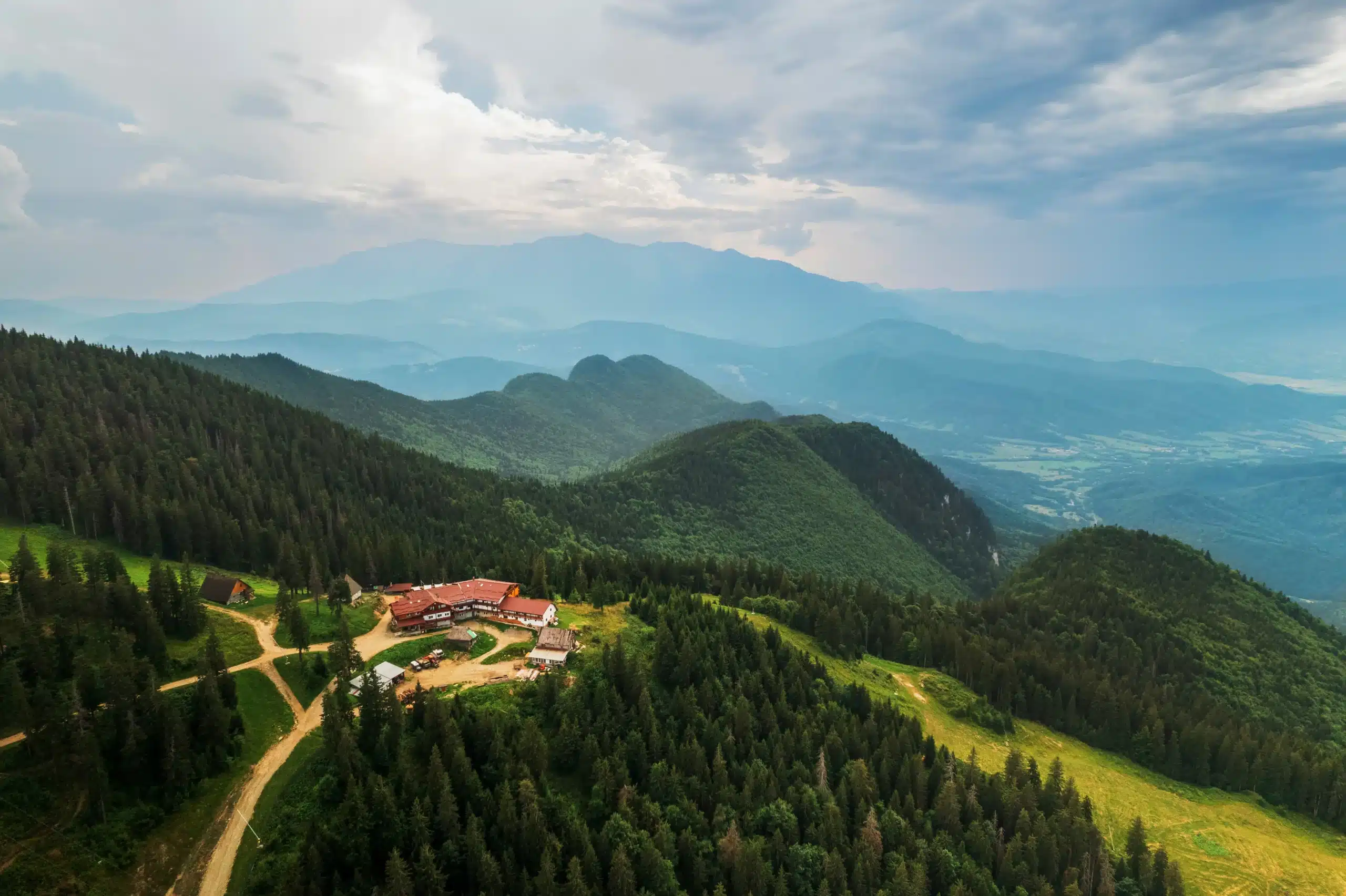 aerial-drone-view-poiana-brasov-romania-touristic-buildings-located-top-mountain-covered-with-lush-forest